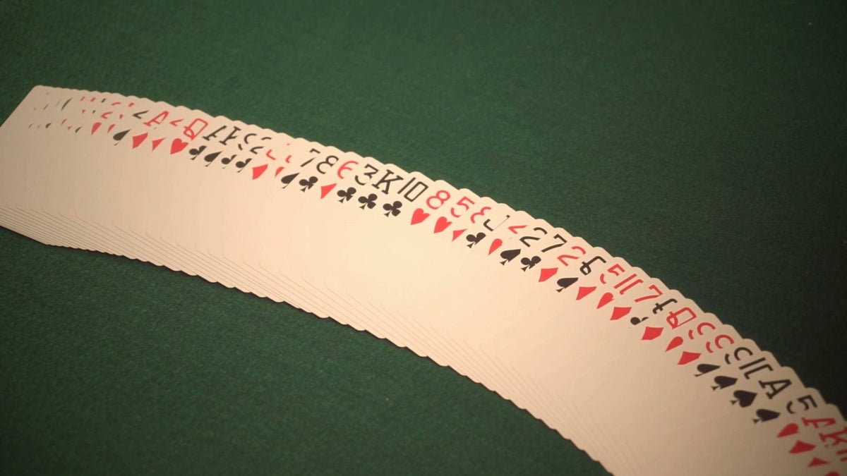 A 52-card deck spread in a line on green felt