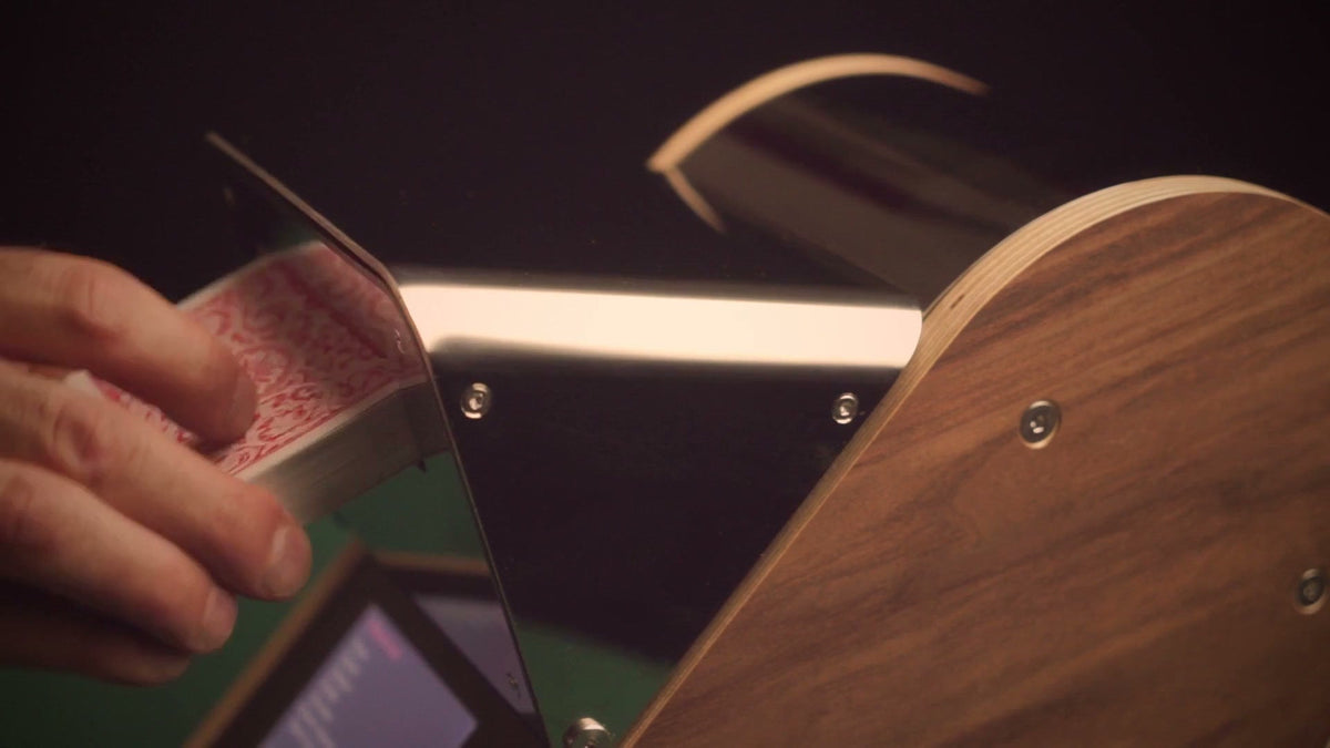 A hand placing a deck face down in LeShuffler's loading tray